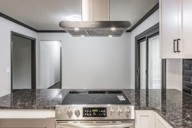 a kitchen with granite countertop a refrigerator and a stove