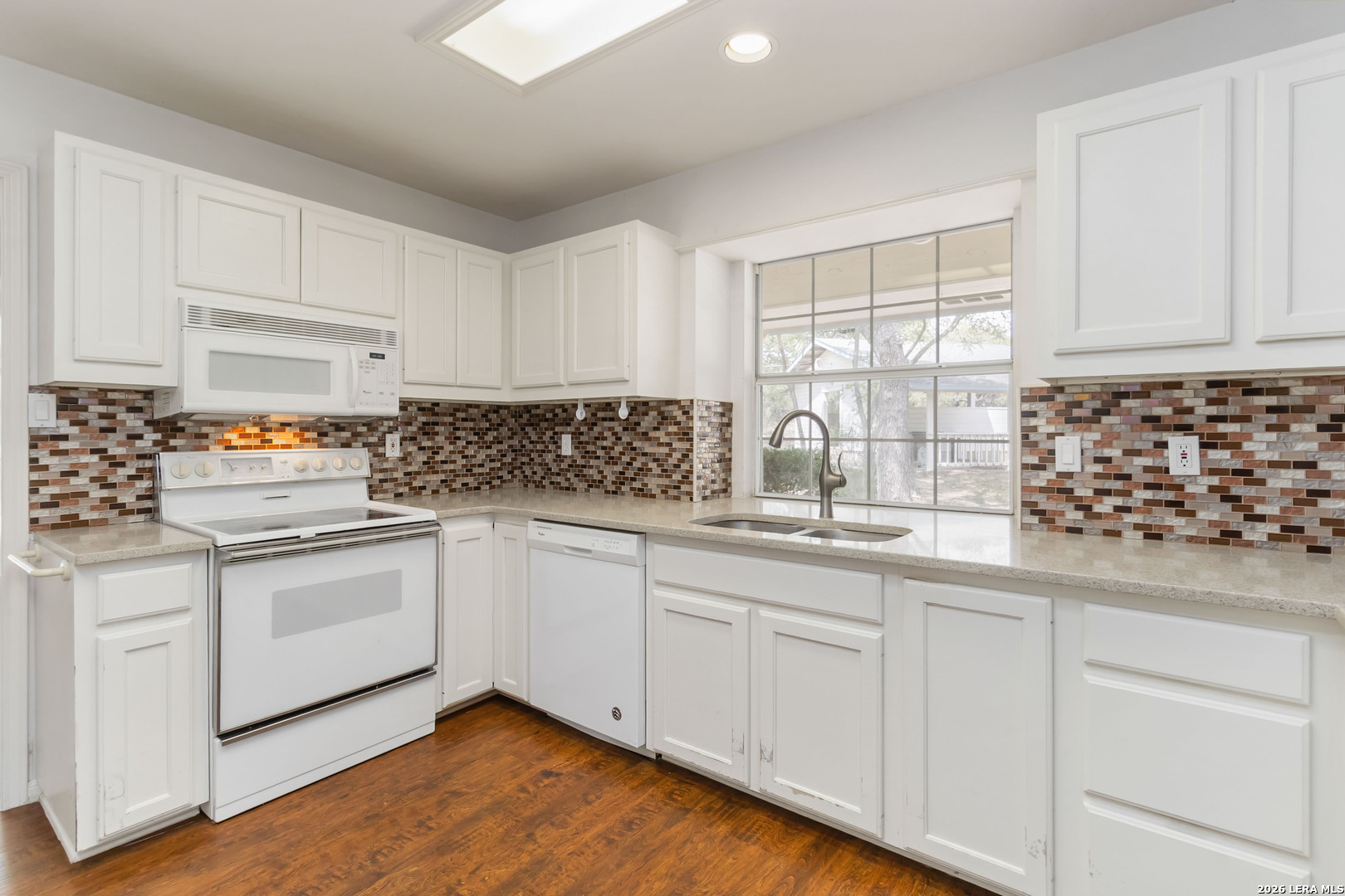 31949 Oak Ridge Parkway Bulverde, TX 78163 - Photo 13 of 50 a kitchen with granite countertop white cabinets and white appliances
