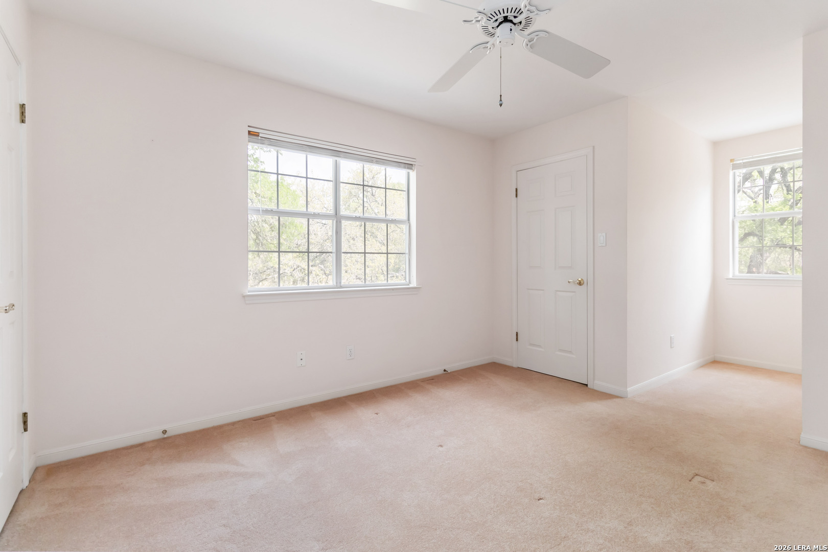 31949 Oak Ridge Parkway Bulverde, TX 78163 - Photo 32 of 50 an empty room with a chandelier fan and windows