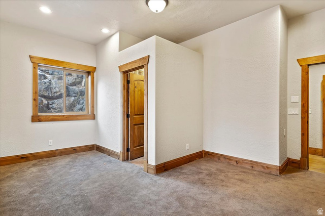 246 Woods Creek Road Morgan, UT 84050 - Photo 68 of 69 Neutral wall finishes, wood-trim window and door frames, wood-panel door, recessed ceiling lighting, and carpeted flooring
