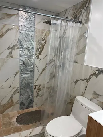 a white toilet sitting next to a shower curtain