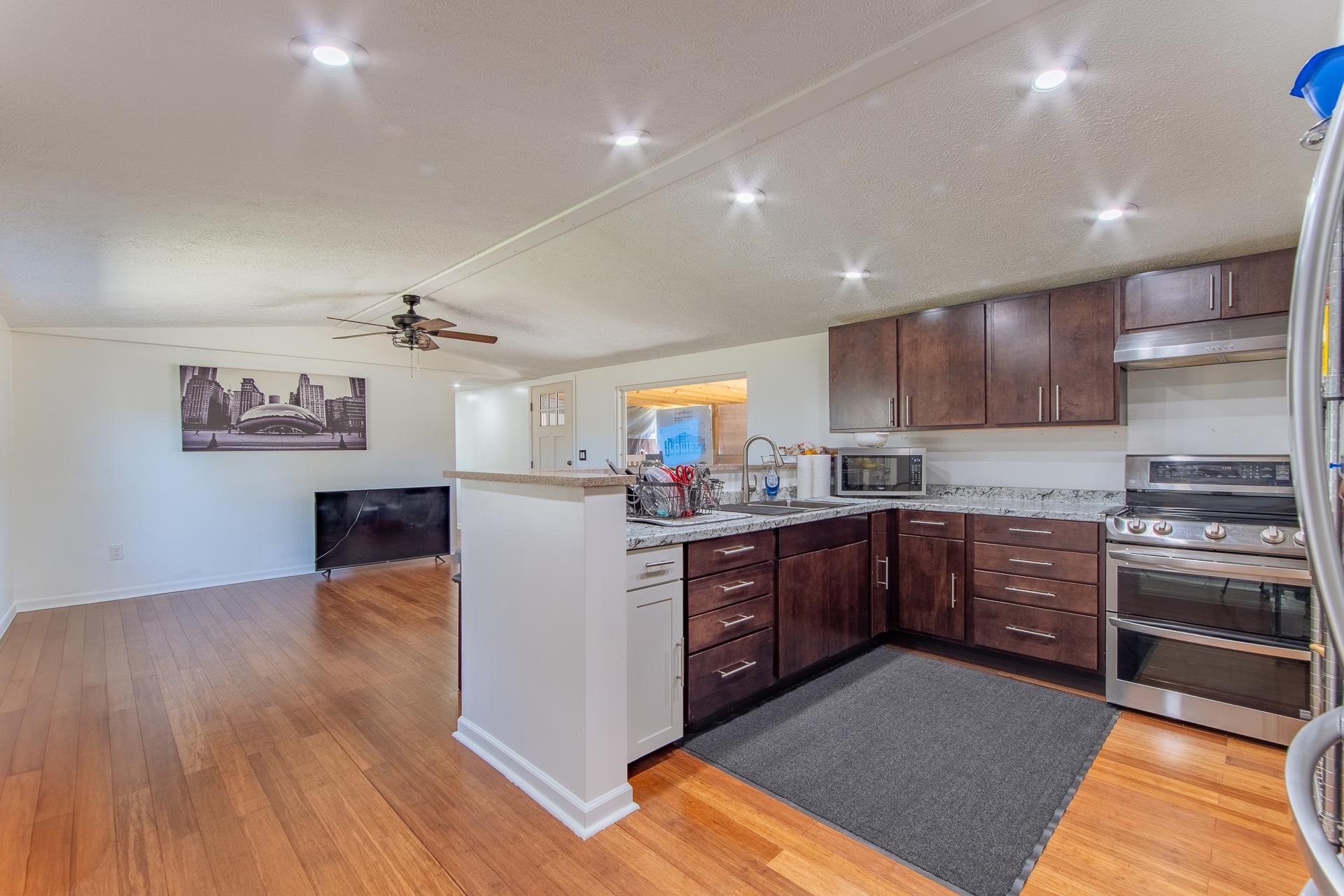 1670 Rose Creek Road Selmer, TN 38375 - Photo 35 of 40 a kitchen with stainless steel appliances granite countertop a stove cabinets and wooden floor