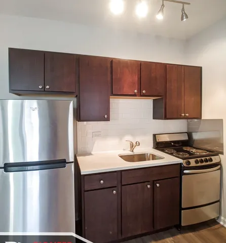 a kitchen with a refrigerator sink and cabinets