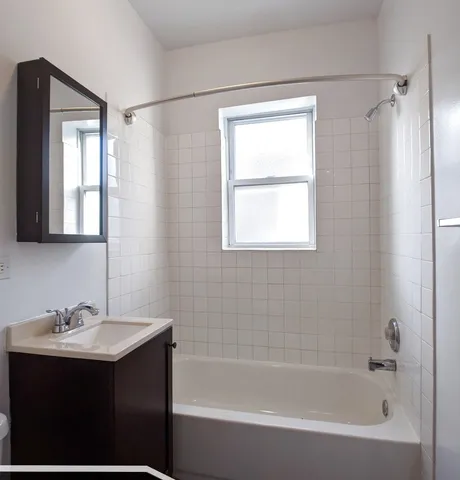 a bathroom with a bathtub sink vanity and mirror