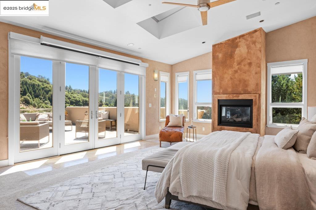 1991 Tunnel Road Berkeley, CA 94705 - Photo 1 of 1 a large bedroom with a large bed and a fireplace