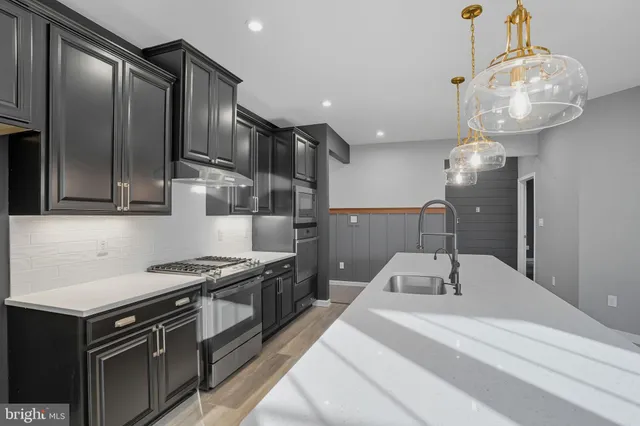 a kitchen with stainless steel appliances granite countertop a stove a refrigerator and a sink