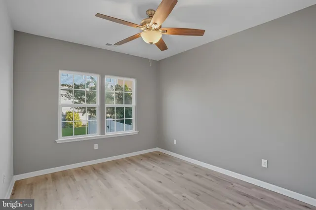 an empty room with a window and a fan