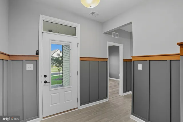 a view of a hallway with wooden cabinets and entryway