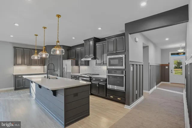 a large kitchen with stainless steel appliances kitchen island granite countertop a stove and refrigerator