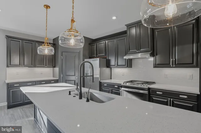 a kitchen with stainless steel appliances a sink a stove and a wooden floor