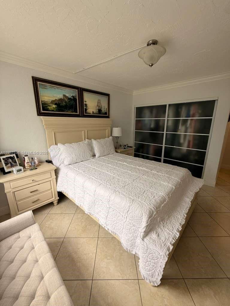 5501 Northwest 7th Street, Unit E207 Miami, FL 33126 - Photo 10 of 13 a bedroom with a bed and a couch