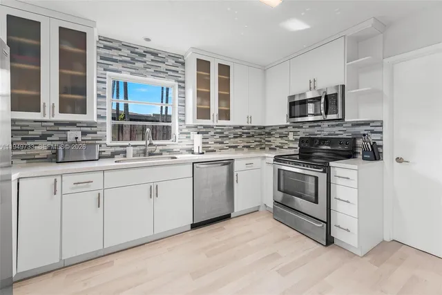 a kitchen with stainless steel appliances granite countertop a stove sink microwave and cabinets