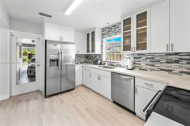 a kitchen with stainless steel appliances a refrigerator sink and cabinets
