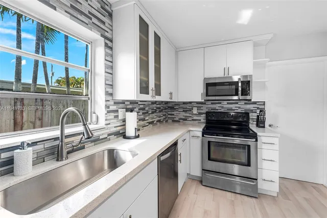 a kitchen with stainless steel appliances a stove a sink and a microwave