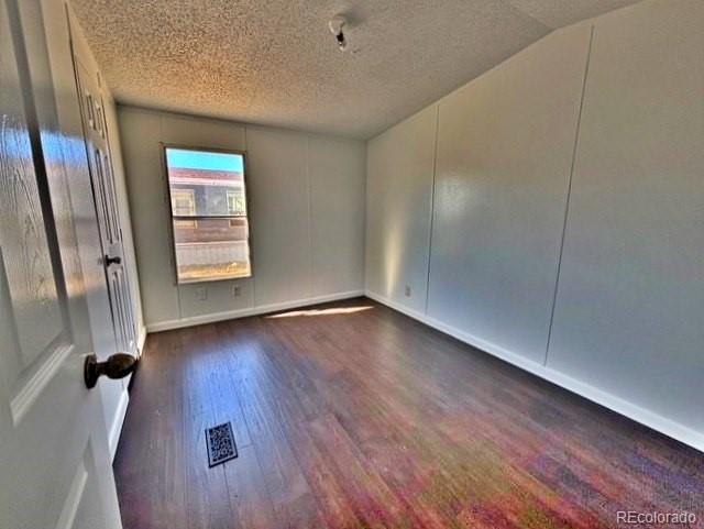 1211 Reed Lane La Junta, CO 81050 - Photo 9 of 17 an empty room with wooden floor and windows