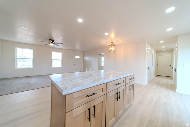 130 Pole Line Road, Unit 2 Roosevelt, UT 84066 - Photo 14 of 33 Kitchen island with a light-toned countertop and natural wood-finish cabinetry