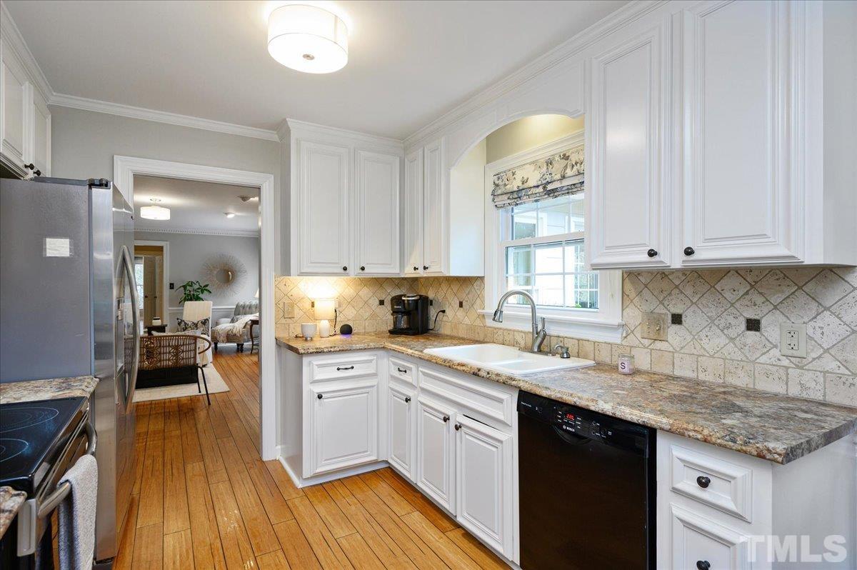 5101 Fielding Drive Raleigh, NC 27606 - Photo 12 of 32 a kitchen with a sink cabinets and wooden floor