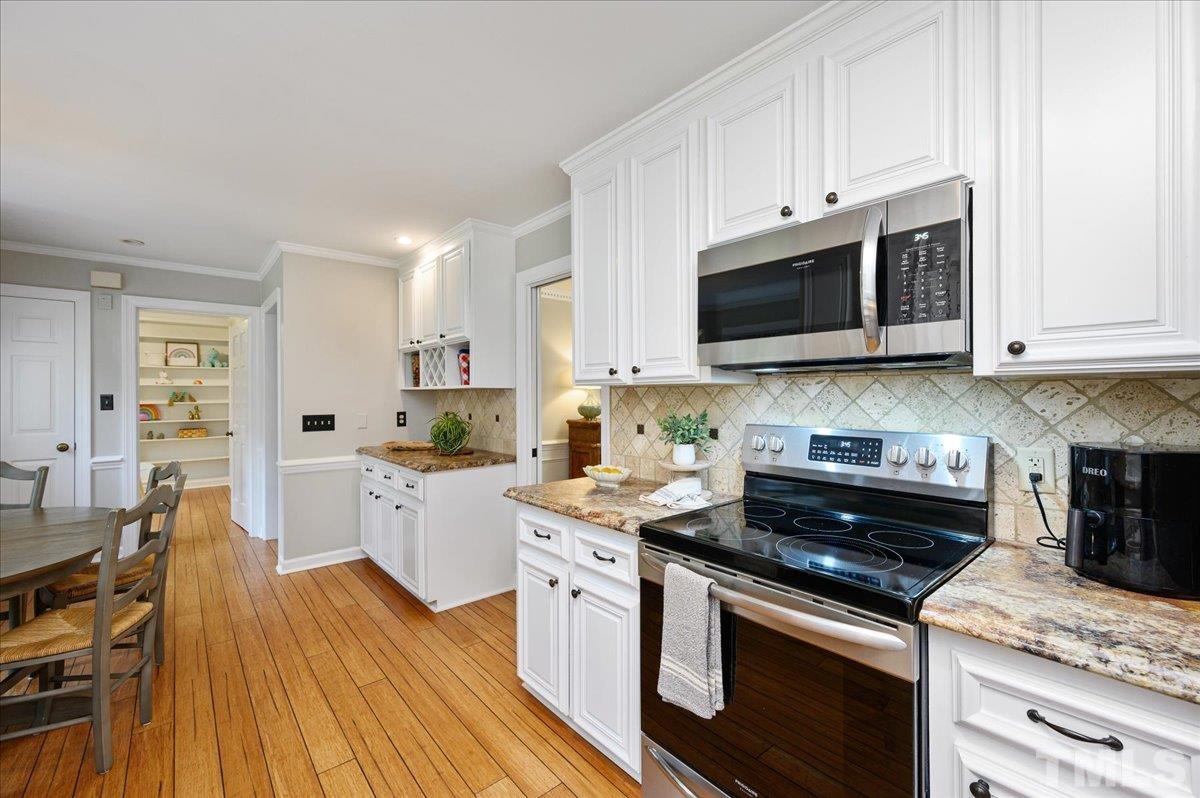 5101 Fielding Drive Raleigh, NC 27606 - Photo 15 of 32 a kitchen with stainless steel appliances white cabinets and stove top oven