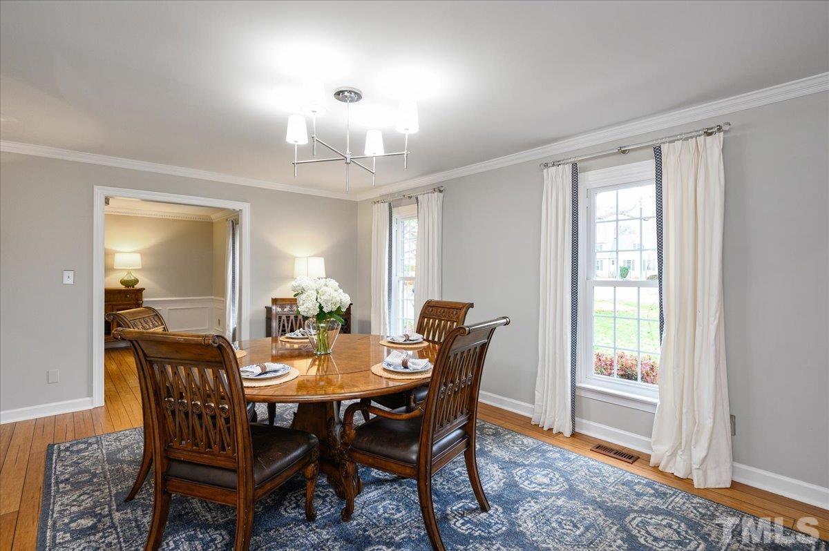 5101 Fielding Drive Raleigh, NC 27606 - Photo 17 of 32 a view of a dining room with furniture a chandelier and wooden floor