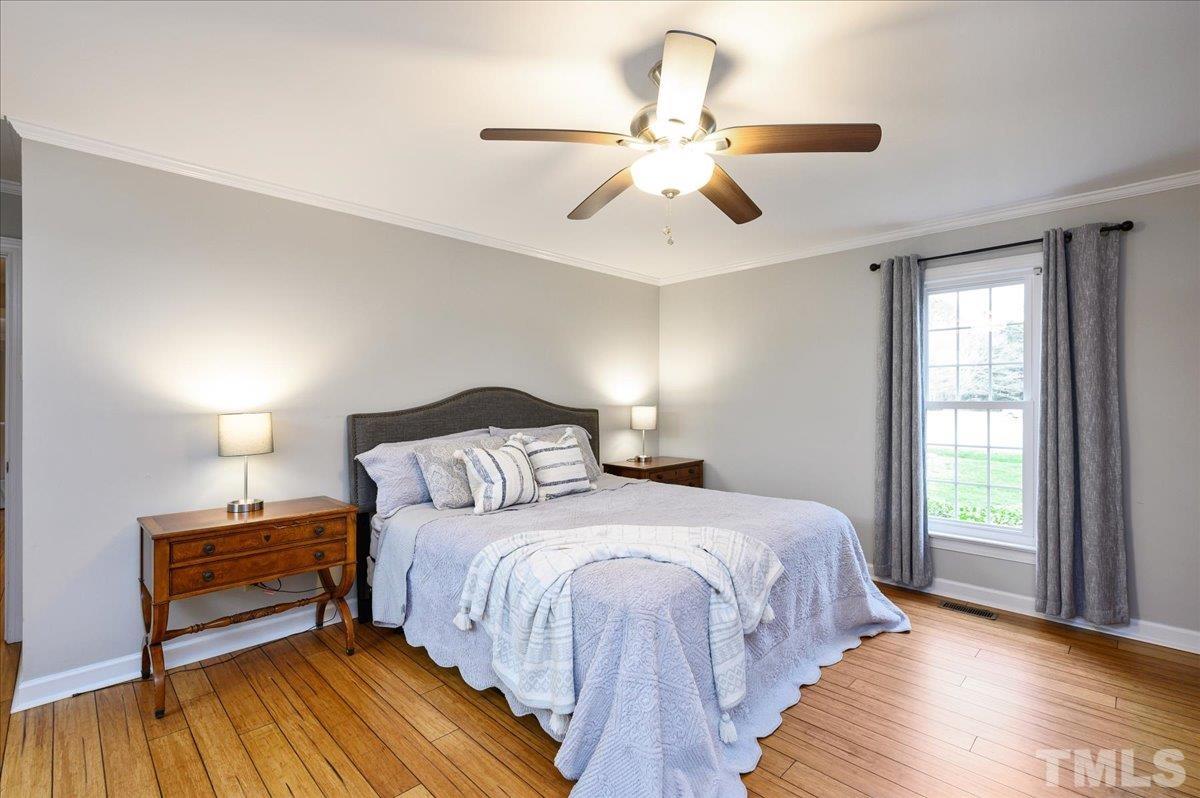 5101 Fielding Drive Raleigh, NC 27606 - Photo 20 of 32 a bedroom with a bed and wooden floor