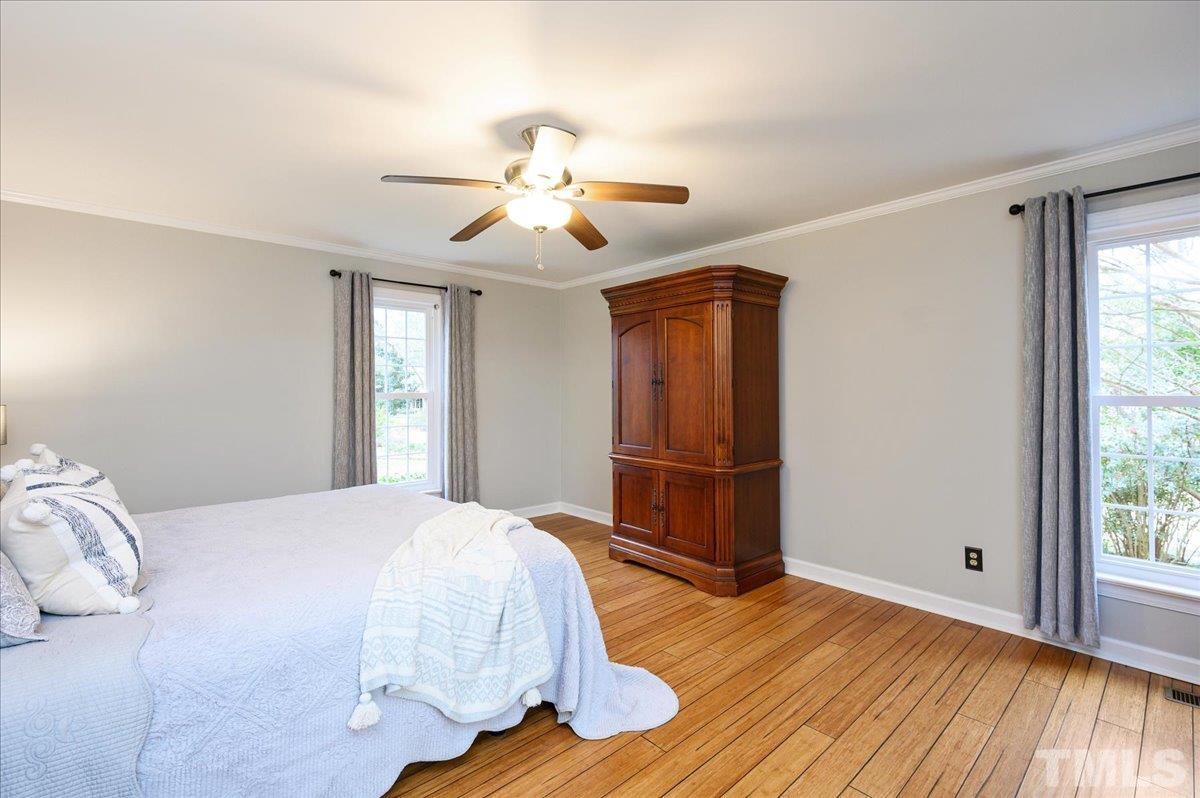 5101 Fielding Drive Raleigh, NC 27606 - Photo 21 of 32 a bedroom with a bed and wooden floor