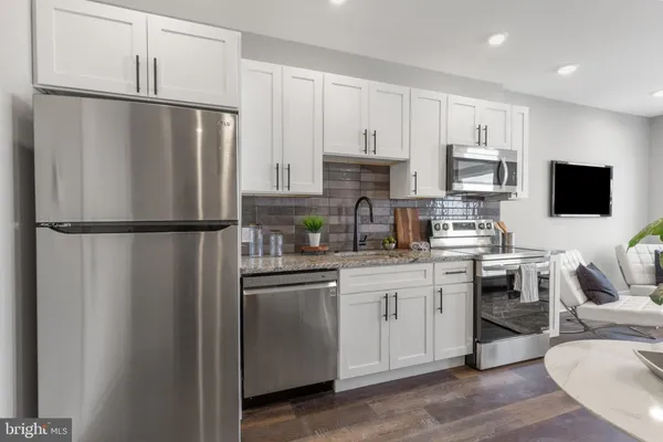 a kitchen with stainless steel appliances a refrigerator sink and microwave