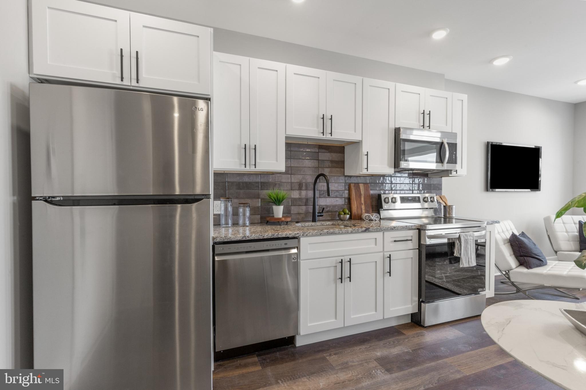 a kitchen with stainless steel appliances a refrigerator sink and microwave