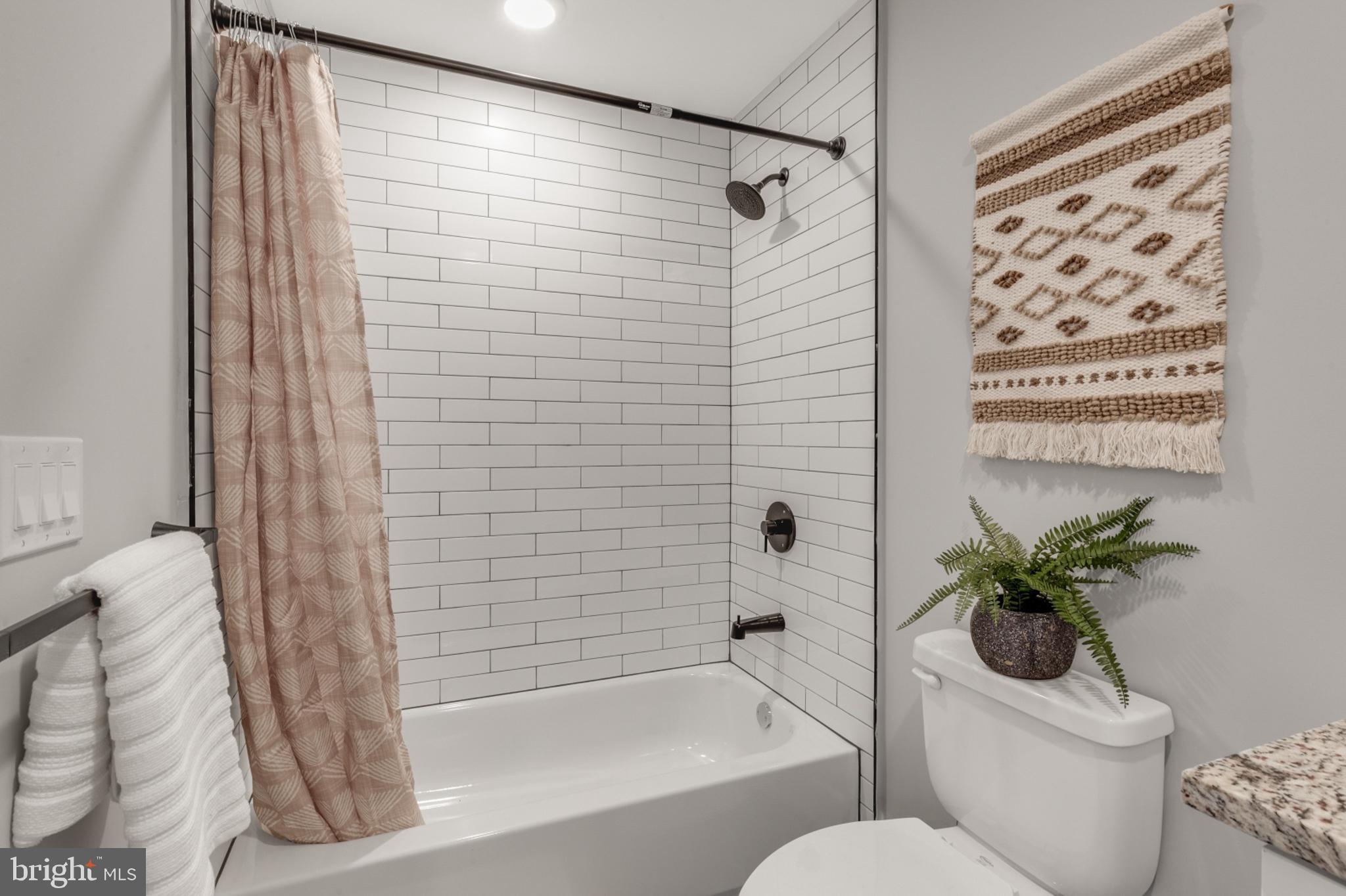 1924 North Front Street, Unit 401 Philadelphia, PA 19122 - Photo 16 of 30 a bathroom with a shower curtain and a toilet