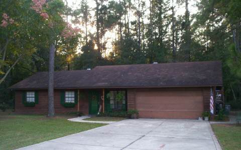 154327 Vikki Road Callahan, FL 32011 - Photo 1 of 1 a front view of a house with a garden and trees