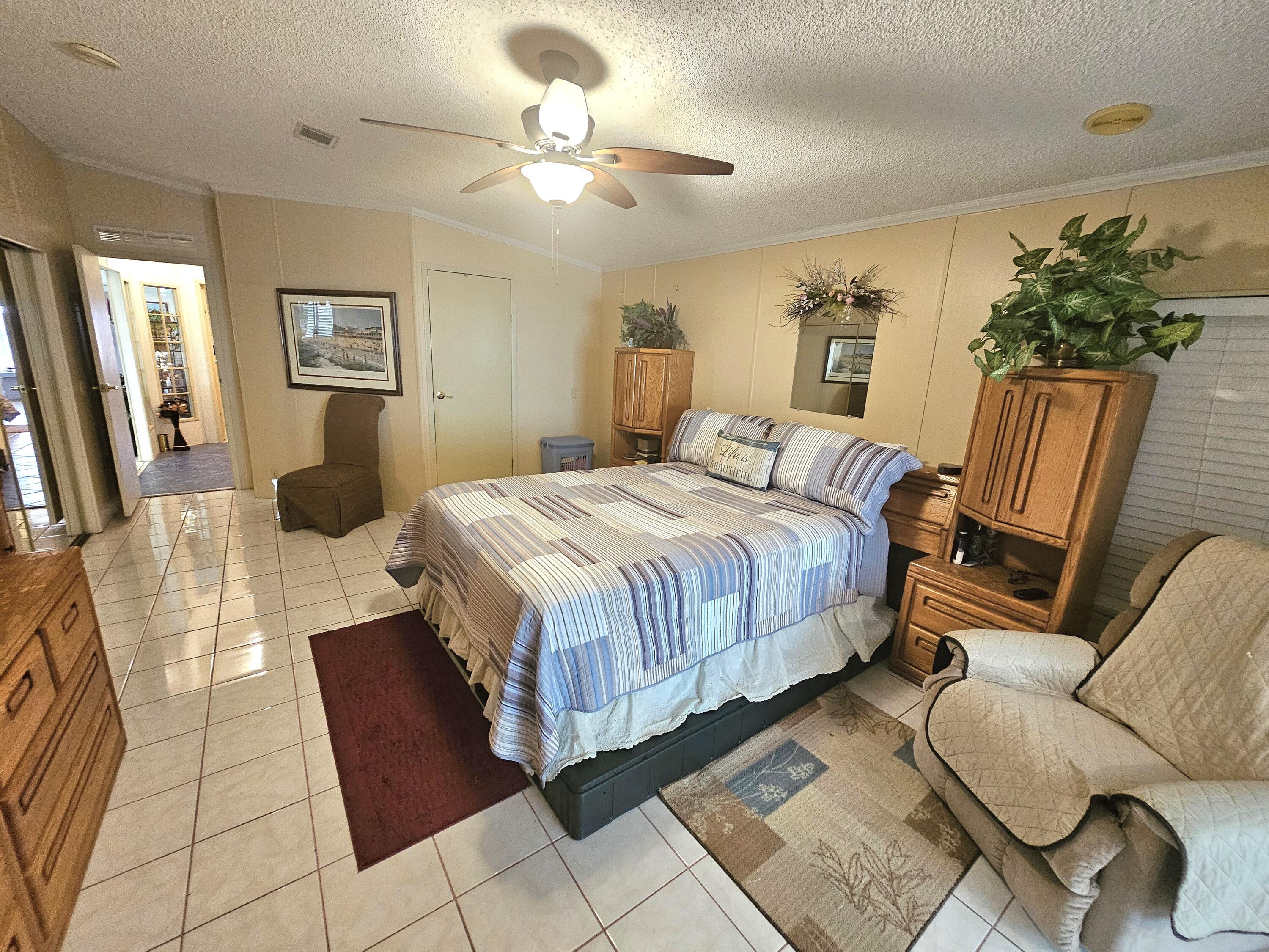 1601 Highway 441, Unit 28 Okeechobee, FL 34974 - Photo 13 of 35 a bedroom with a bed a couch and dresser