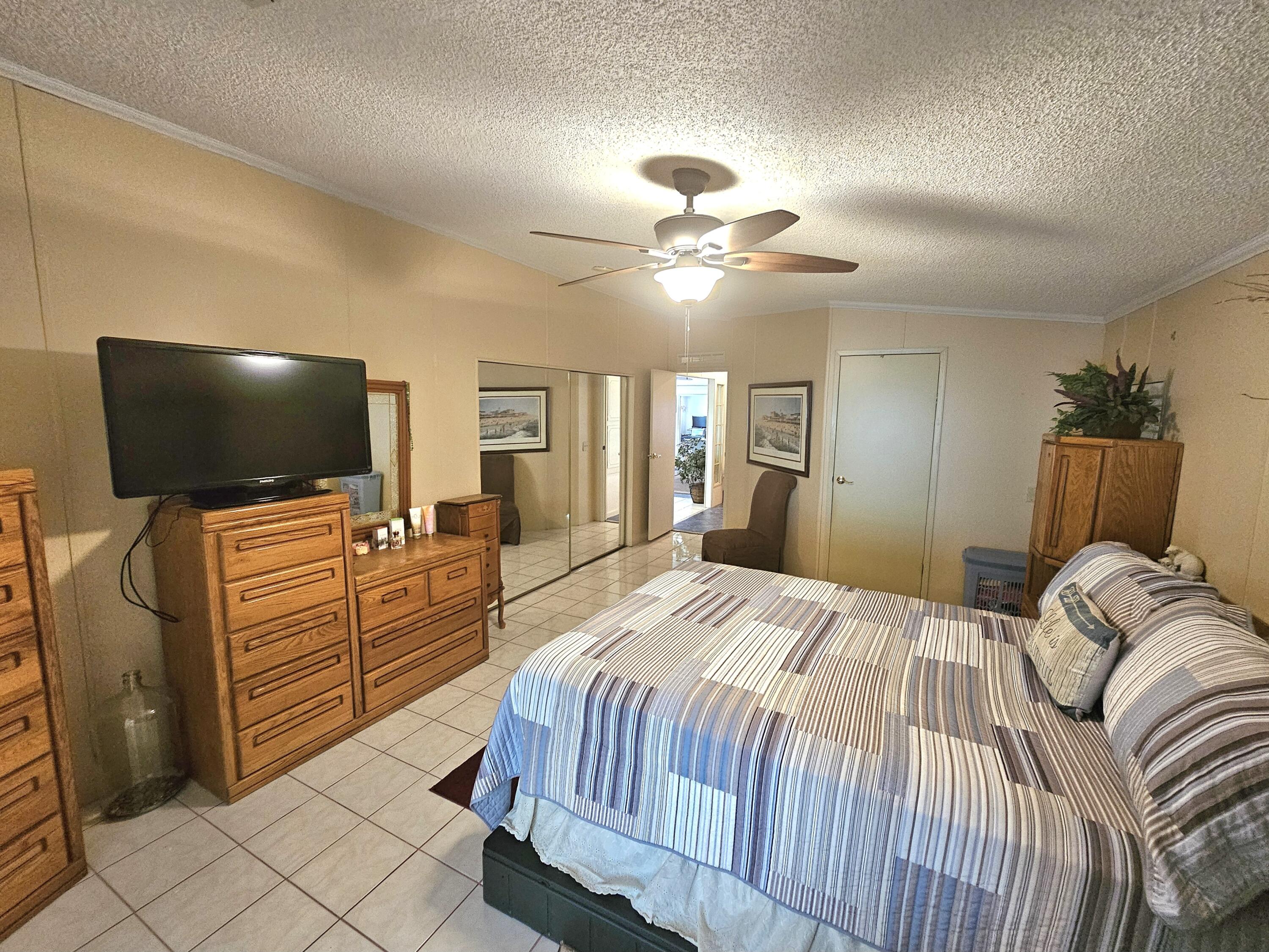 1601 Highway 441, Unit 28 Okeechobee, FL 34974 - Photo 14 of 35 a bedroom with a bed and a flat screen tv