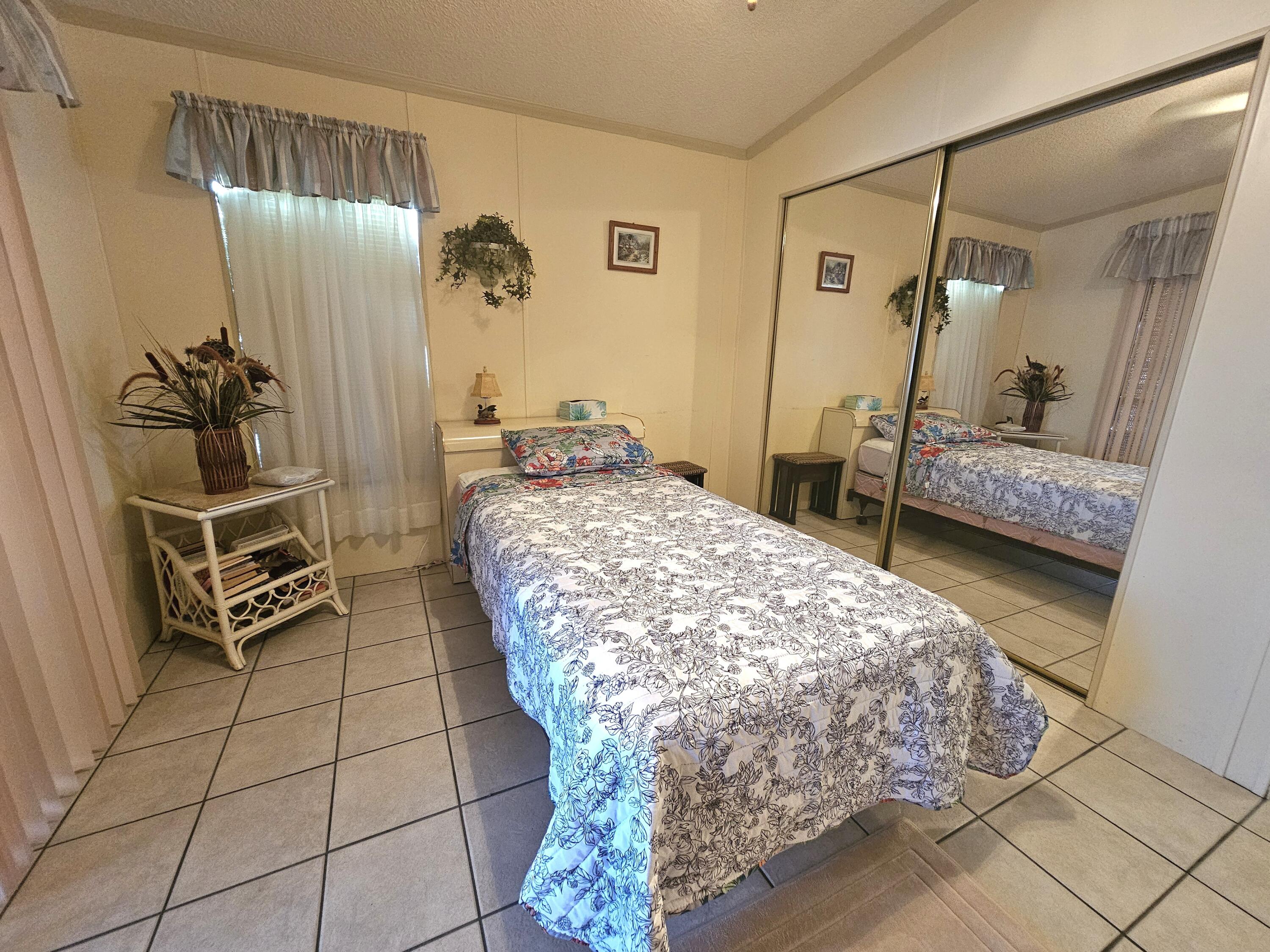 1601 Highway 441, Unit 28 Okeechobee, FL 34974 - Photo 16 of 35 a bedroom with a bed and a mirror