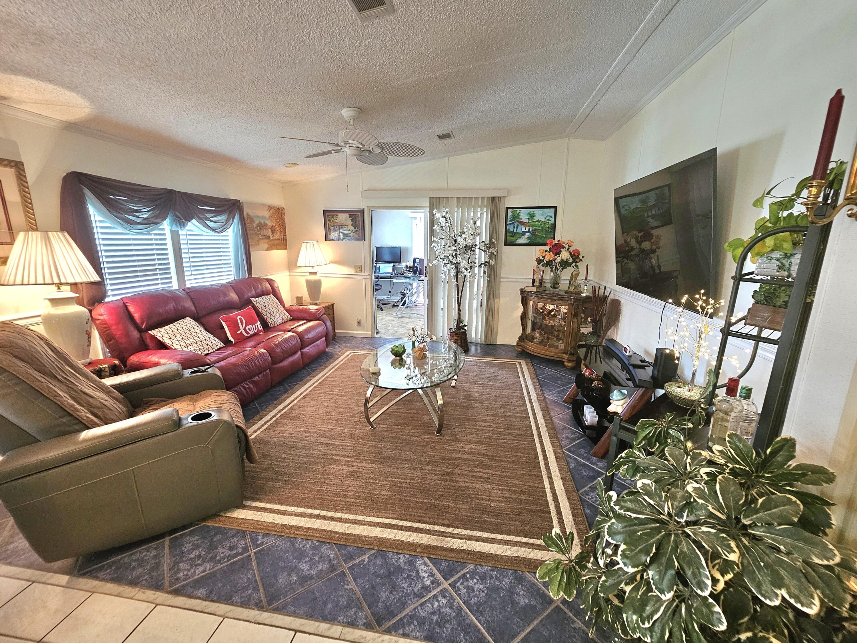1601 Highway 441, Unit 28 Okeechobee, FL 34974 - Photo 2 of 35 a living room with patio furniture and a flat screen tv