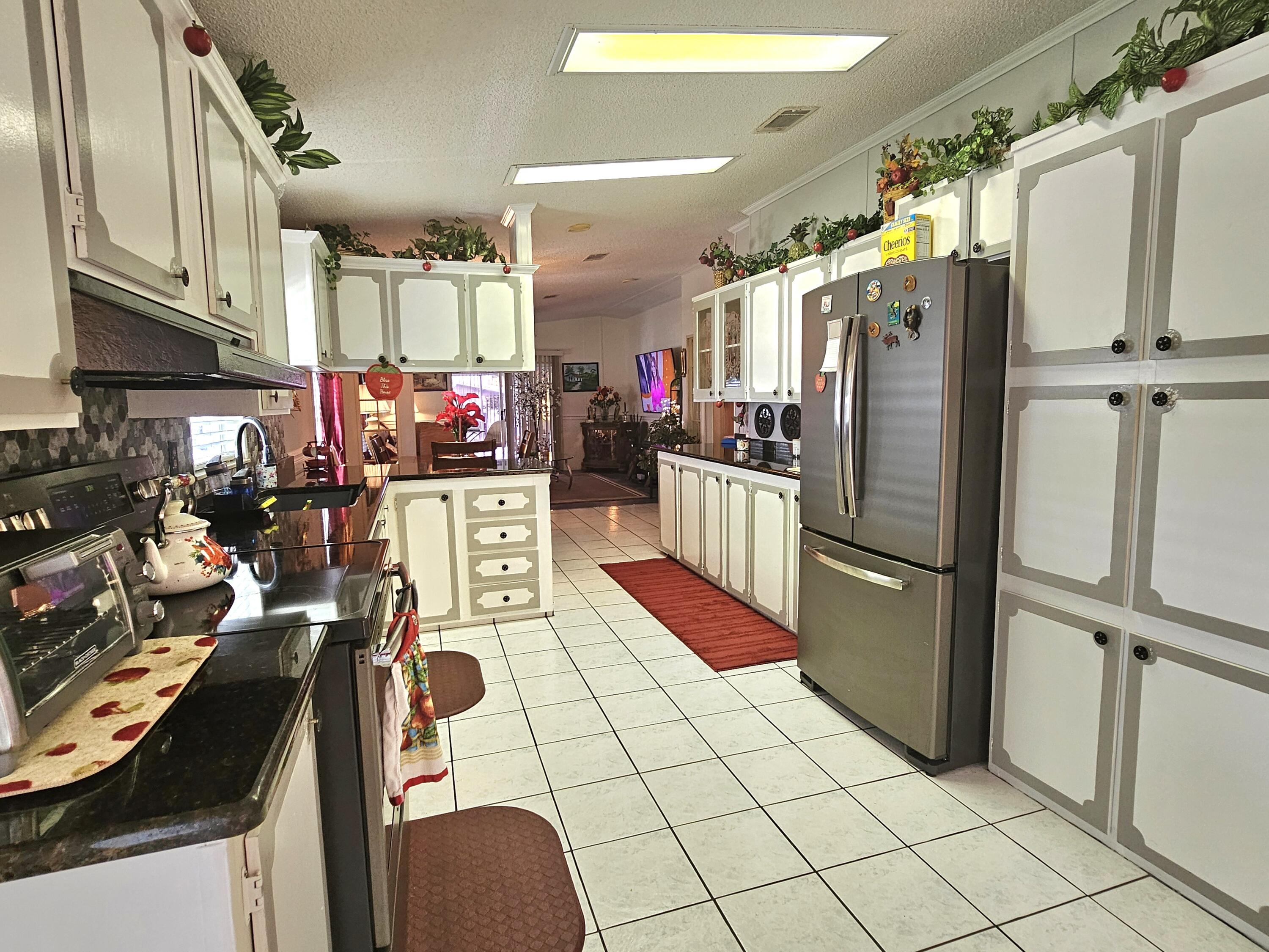 1601 Highway 441, Unit 28 Okeechobee, FL 34974 - Photo 6 of 35 a kitchen with stainless steel appliances granite countertop a refrigerator and a stove top oven