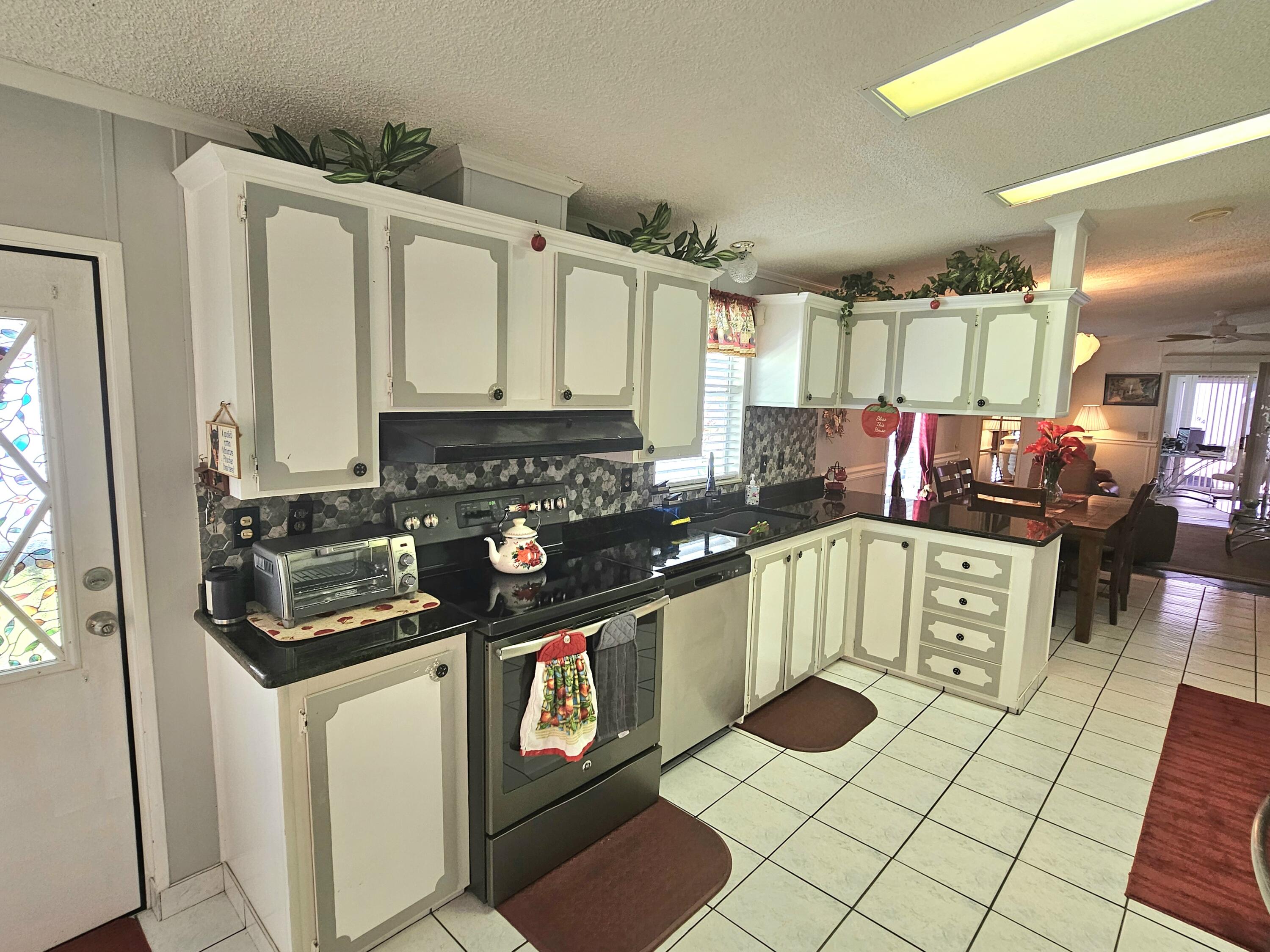 1601 Highway 441, Unit 28 Okeechobee, FL 34974 - Photo 7 of 35 a kitchen with stainless steel appliances a sink stove and cabinets