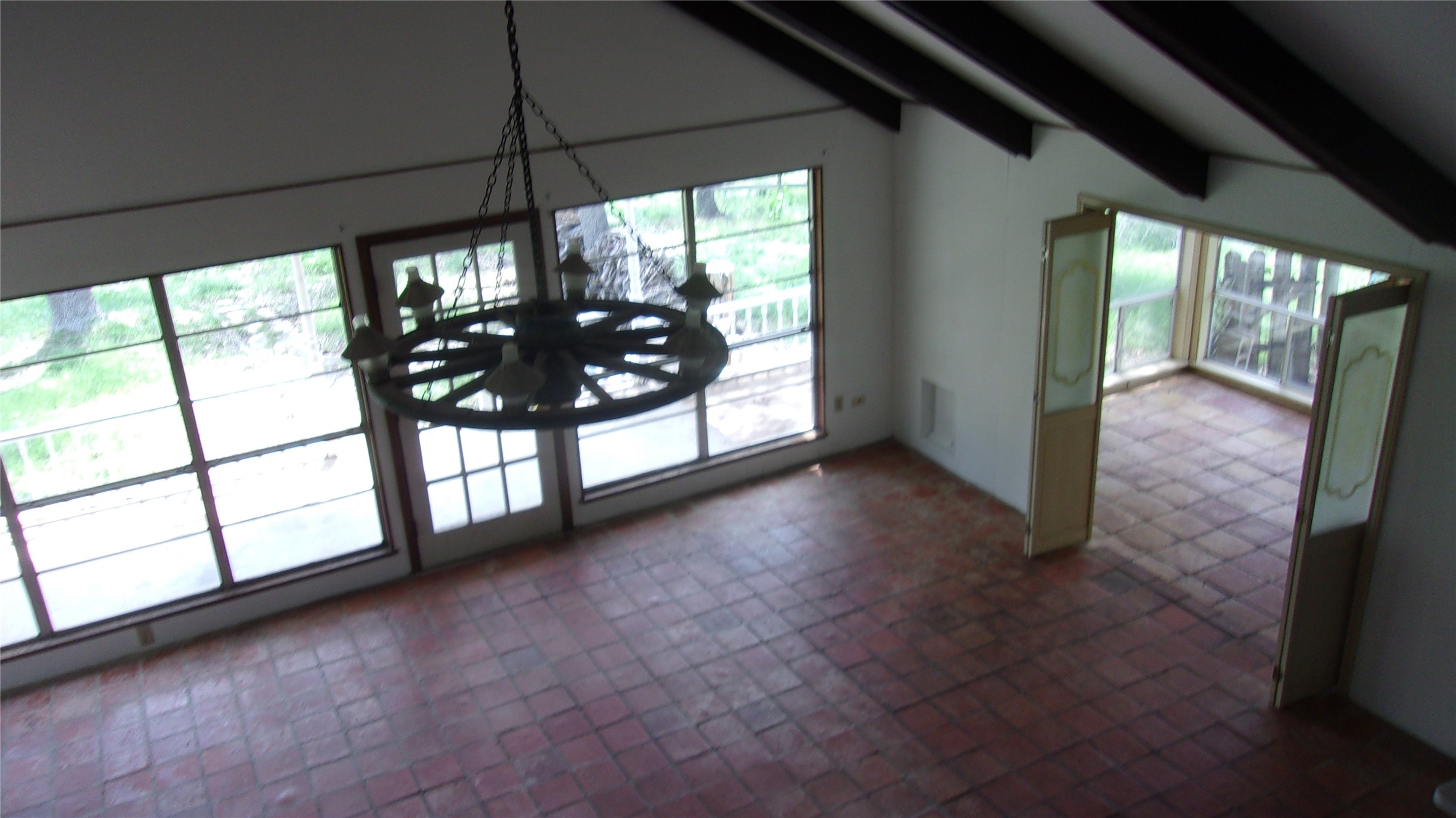 702 Cottonwood Creek Road Dripping Springs, TX 78620 - Photo 11 of 31 Spacious room featuring vaulted ceilings with exposed beams, terra cotta tile flooring, and large windows