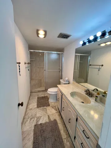 a spacious bathroom with a double vanity sink a toilet and a shower