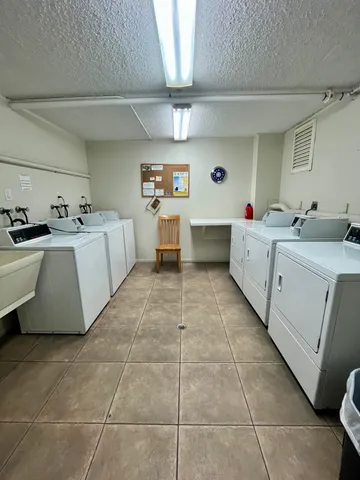 a large white kitchen with a stove a sink a counter top space and cabinets