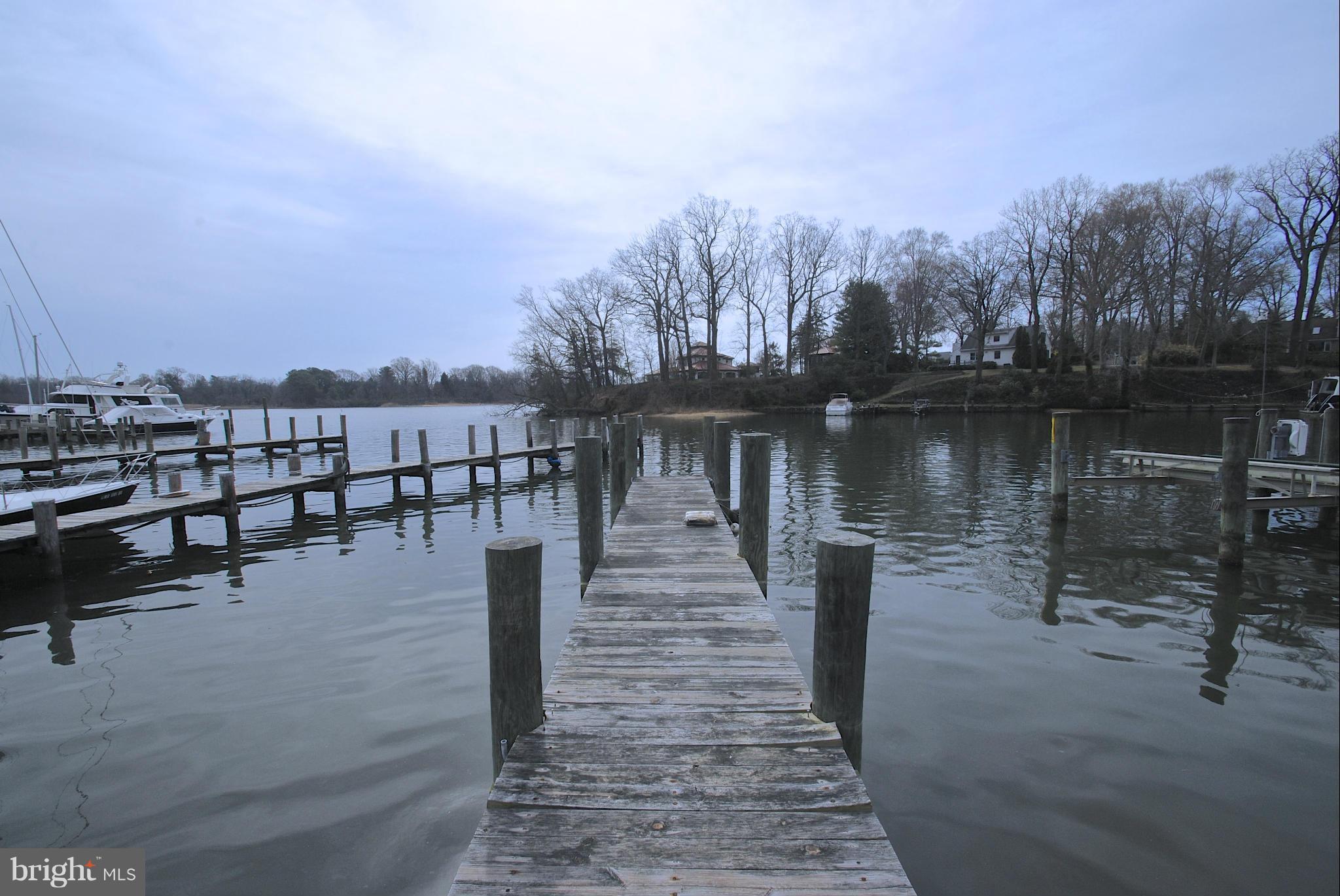 717 Red Cedar Road Annapolis, MD 21409 - Photo 27 of 30 a view of a lake with a bench next to a lake