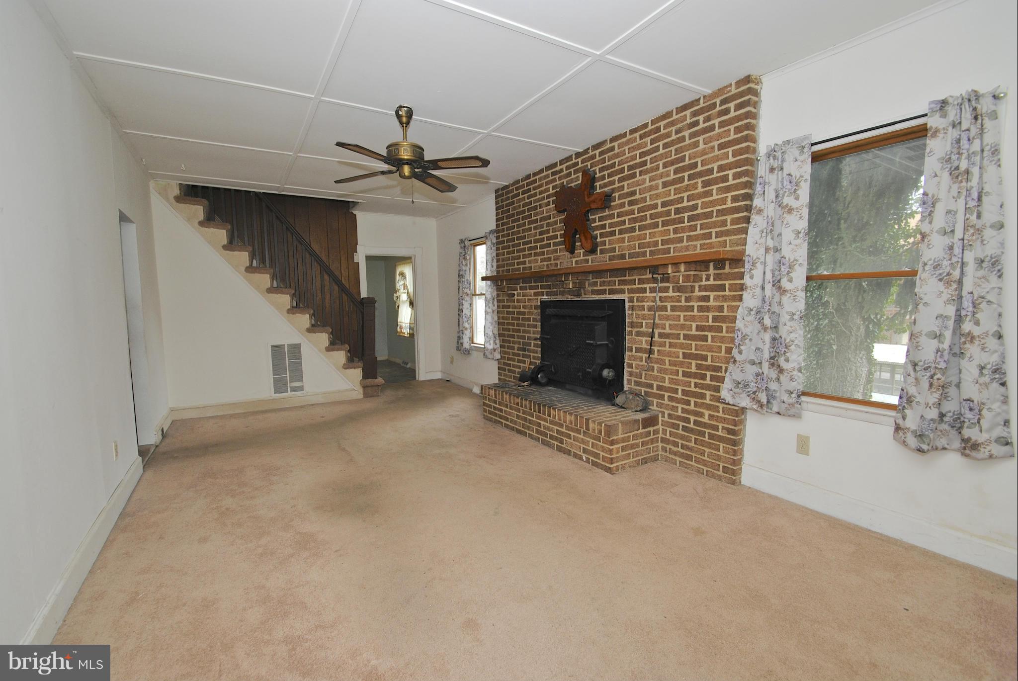 717 Red Cedar Road Annapolis, MD 21409 - Photo 10 of 30 a view of a livingroom with a fireplace a ceiling fan and windows