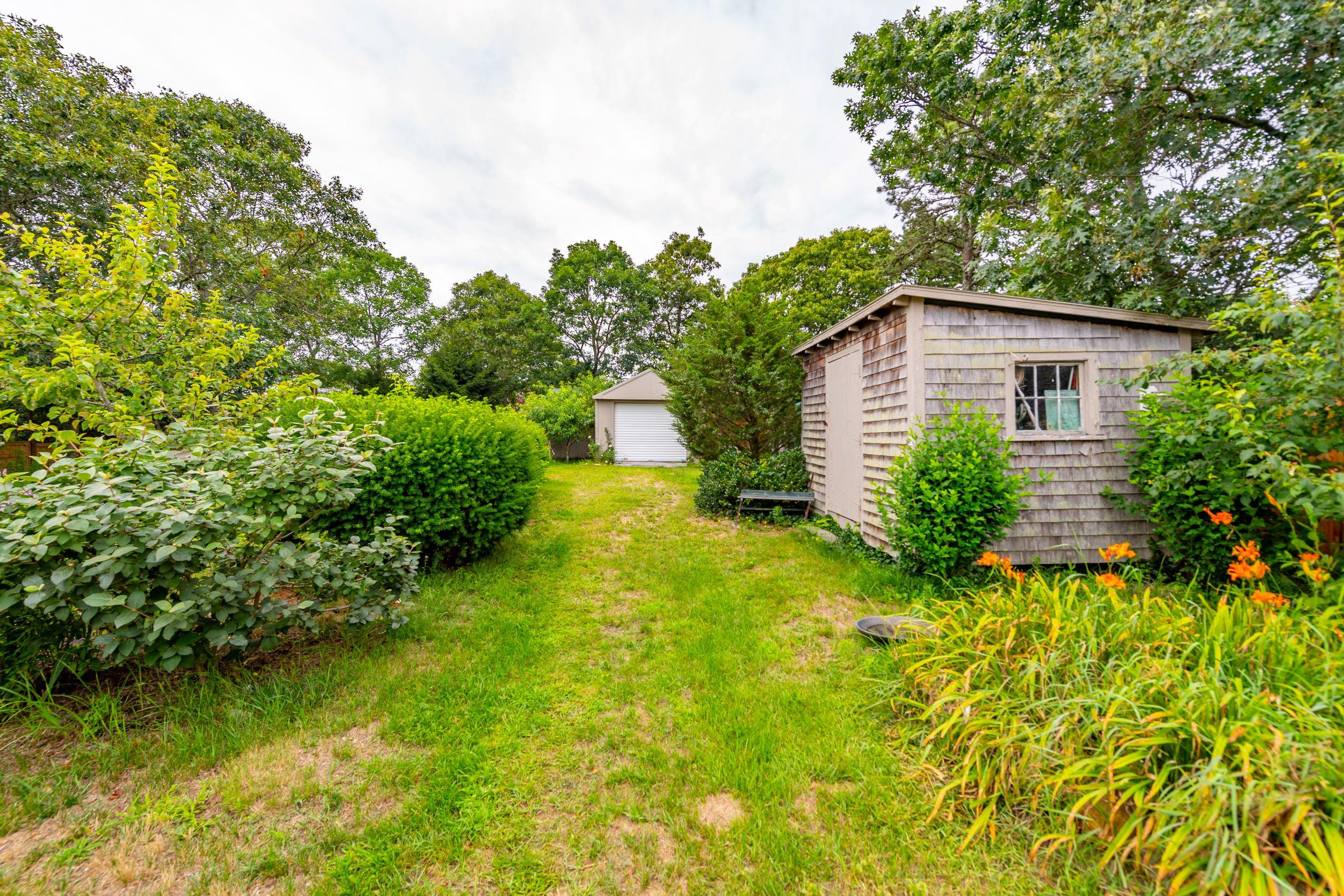 249 West Tisbury Road Edgartown, MA 02539 - Photo 18 of 24 a view of a backyard with plants and large trees