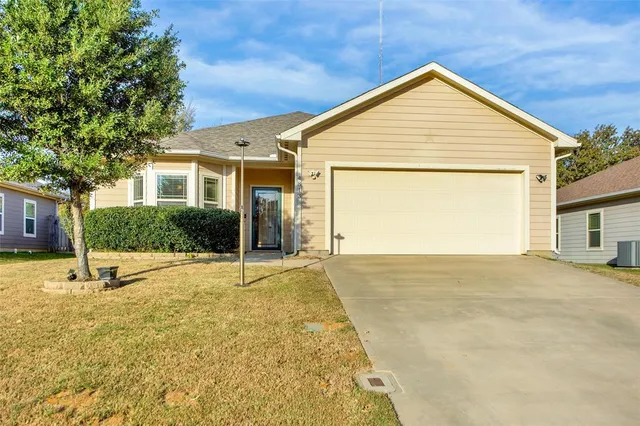a view of an house with backyard and a garage