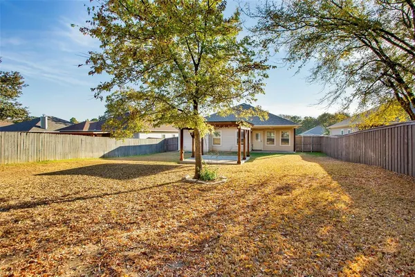 a yard with trees in the background