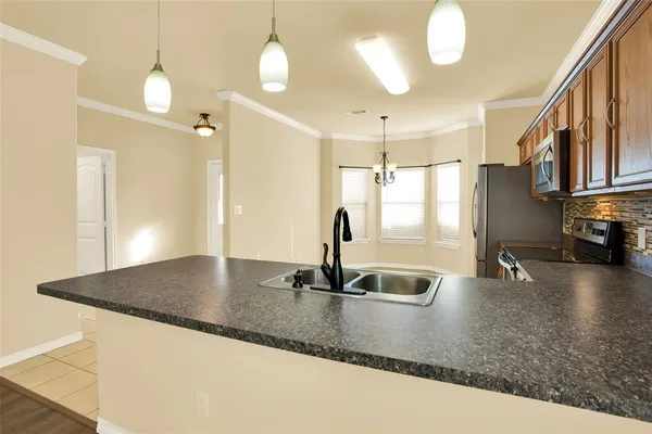 a kitchen with stainless steel appliances granite countertop a sink window and a refrigerator