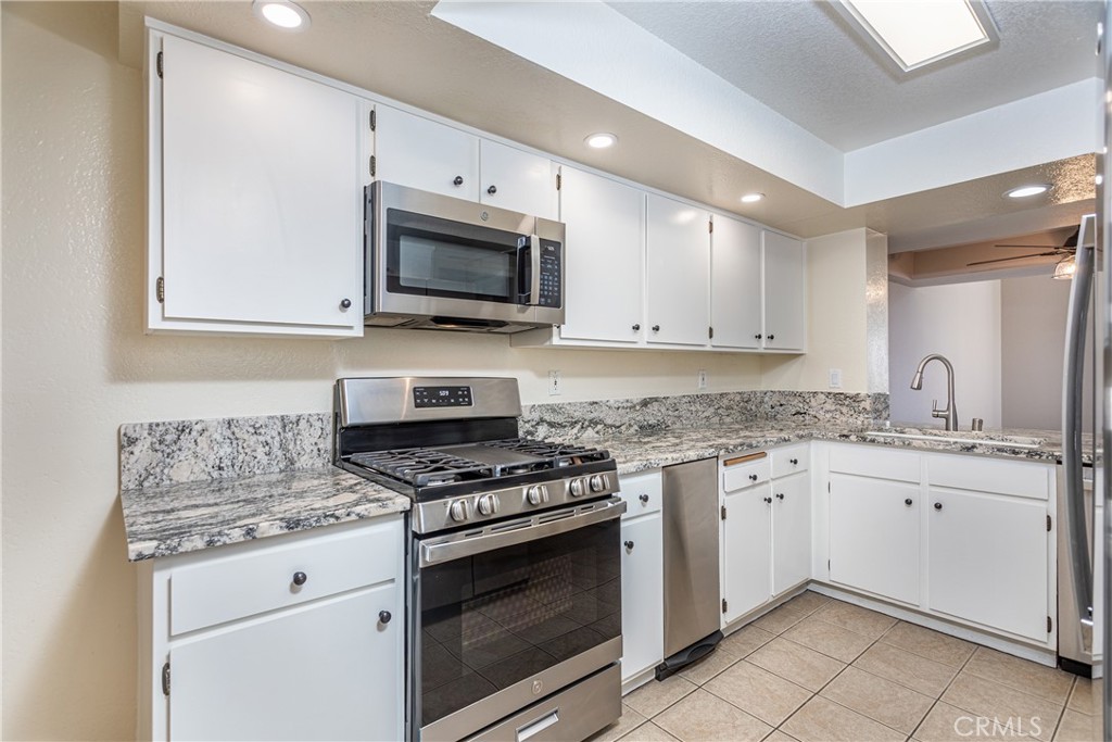 230 Bethany Road, Unit 306 Burbank, CA 91504 - Photo 15 of 44 a kitchen with granite countertop a sink stove and microwave