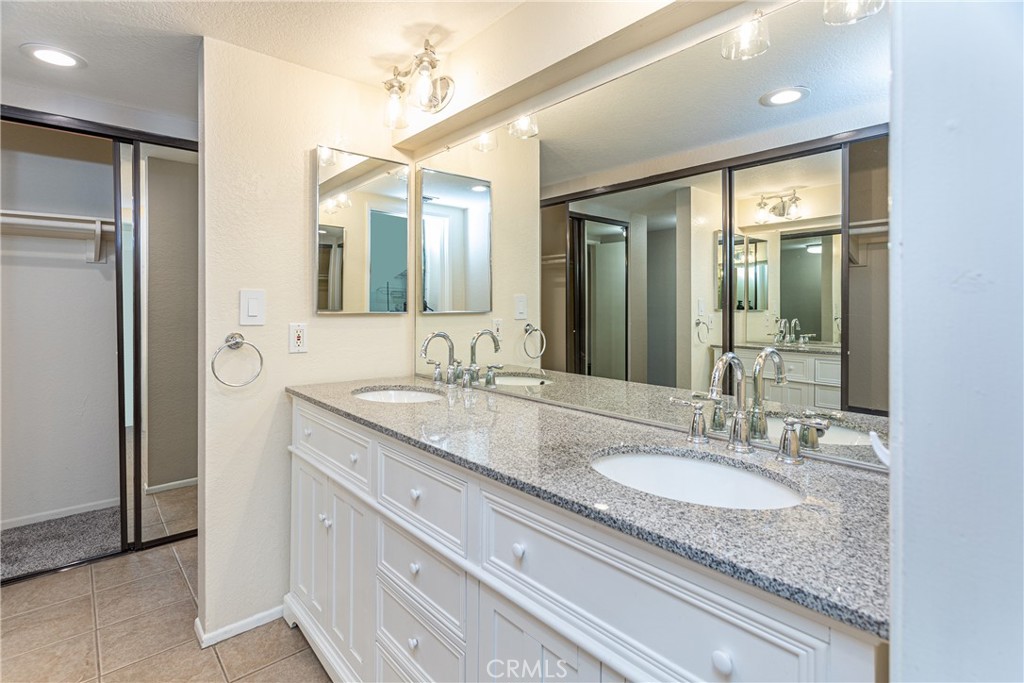 230 Bethany Road, Unit 306 Burbank, CA 91504 - Photo 27 of 44 a bathroom with a granite countertop sink and a mirror