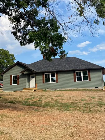 a house that has a tree in front of it