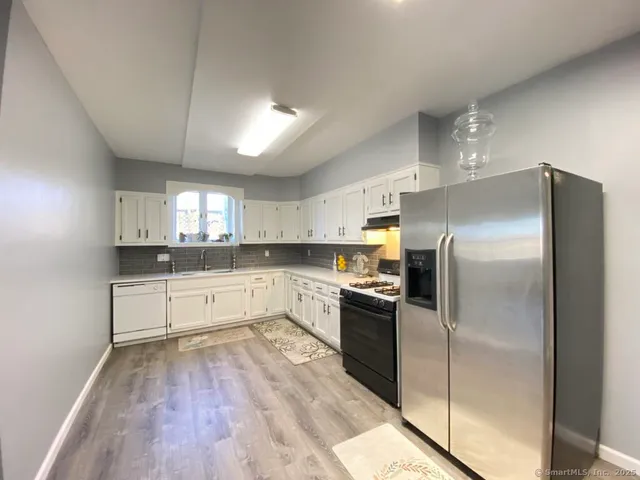a kitchen with a refrigerator and a stove top oven