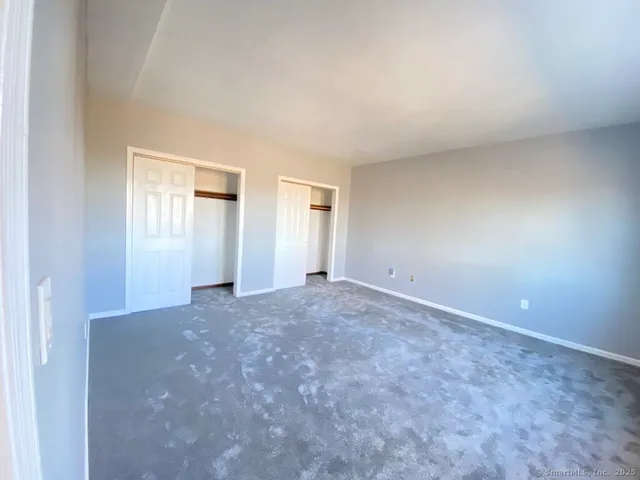 an empty room with windows and closet