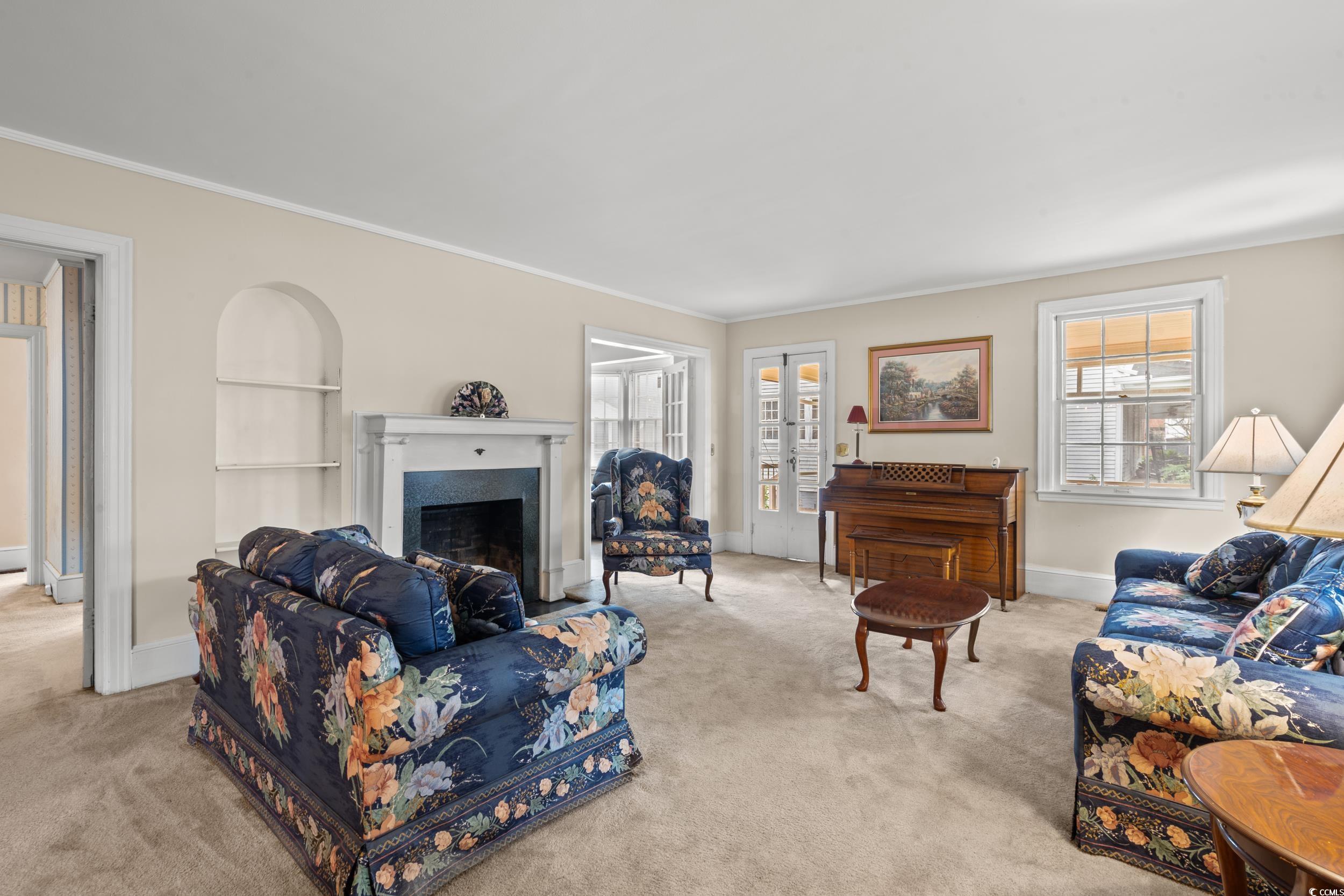 310 North Main Street Mullins, SC 29574 - Photo 28 of 35 Living area with carpet floors, a fireplace, crown molding, and built in shelves